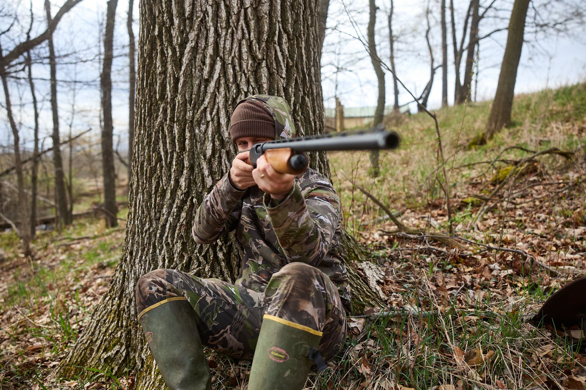 A hunter aims a firearm, what to do if a hang fire happens while hunting concept. 