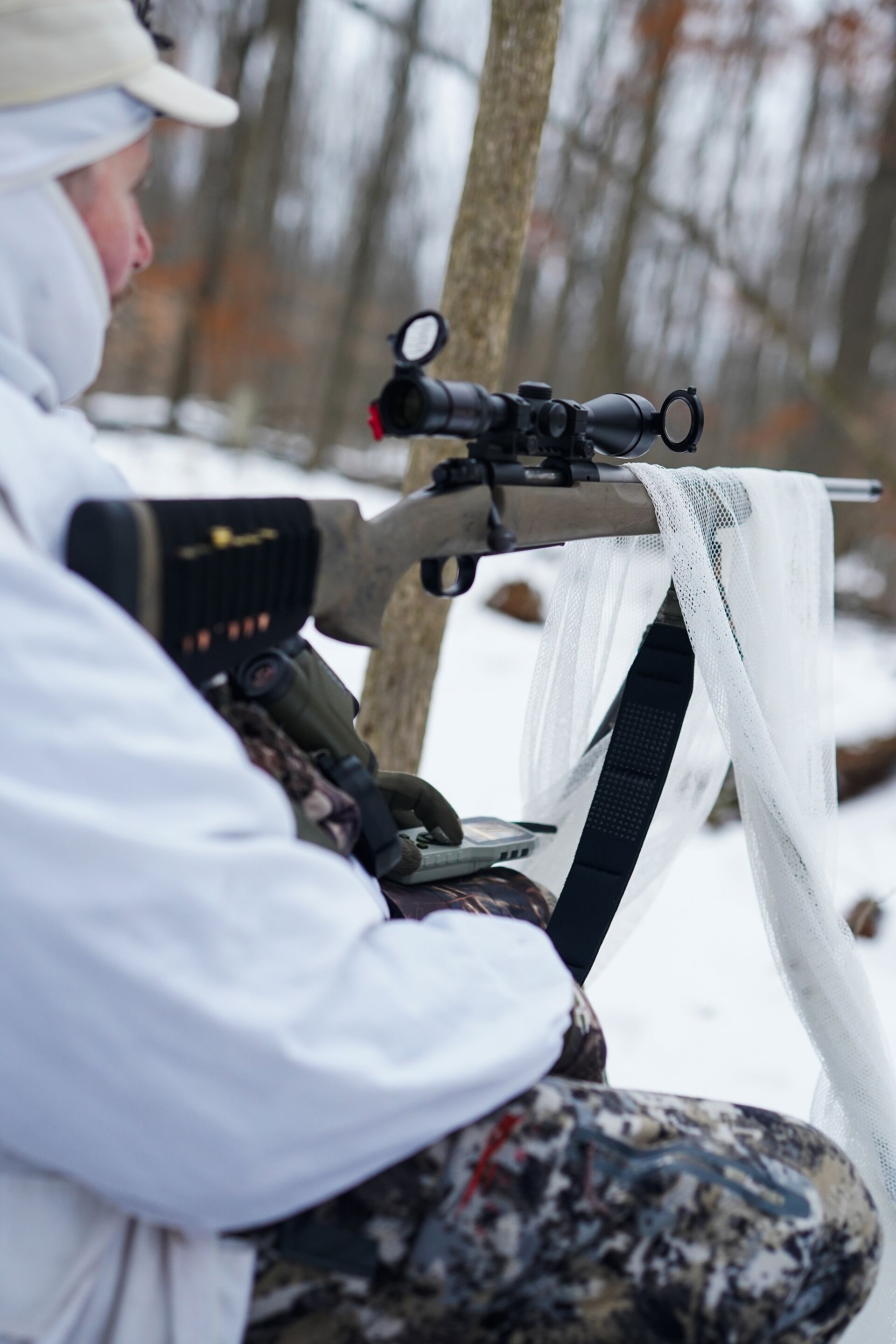 A coyote hunter waits patiently with a rifle, coyote hunting tips and tactics concept. 