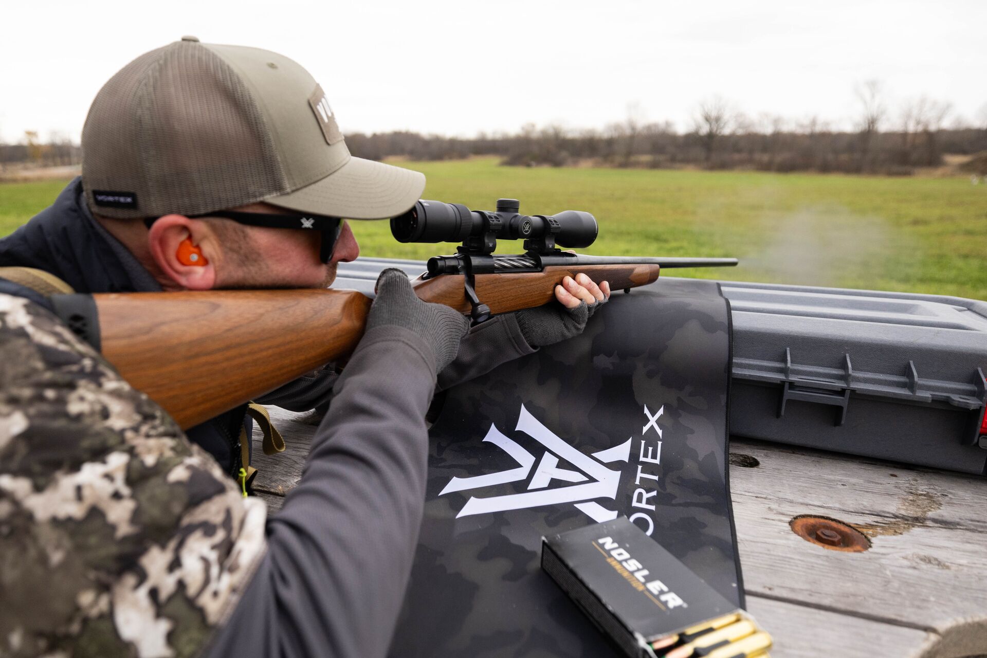 A hunter aims a rifle, sighting in a rifle scope for hunting concept. 