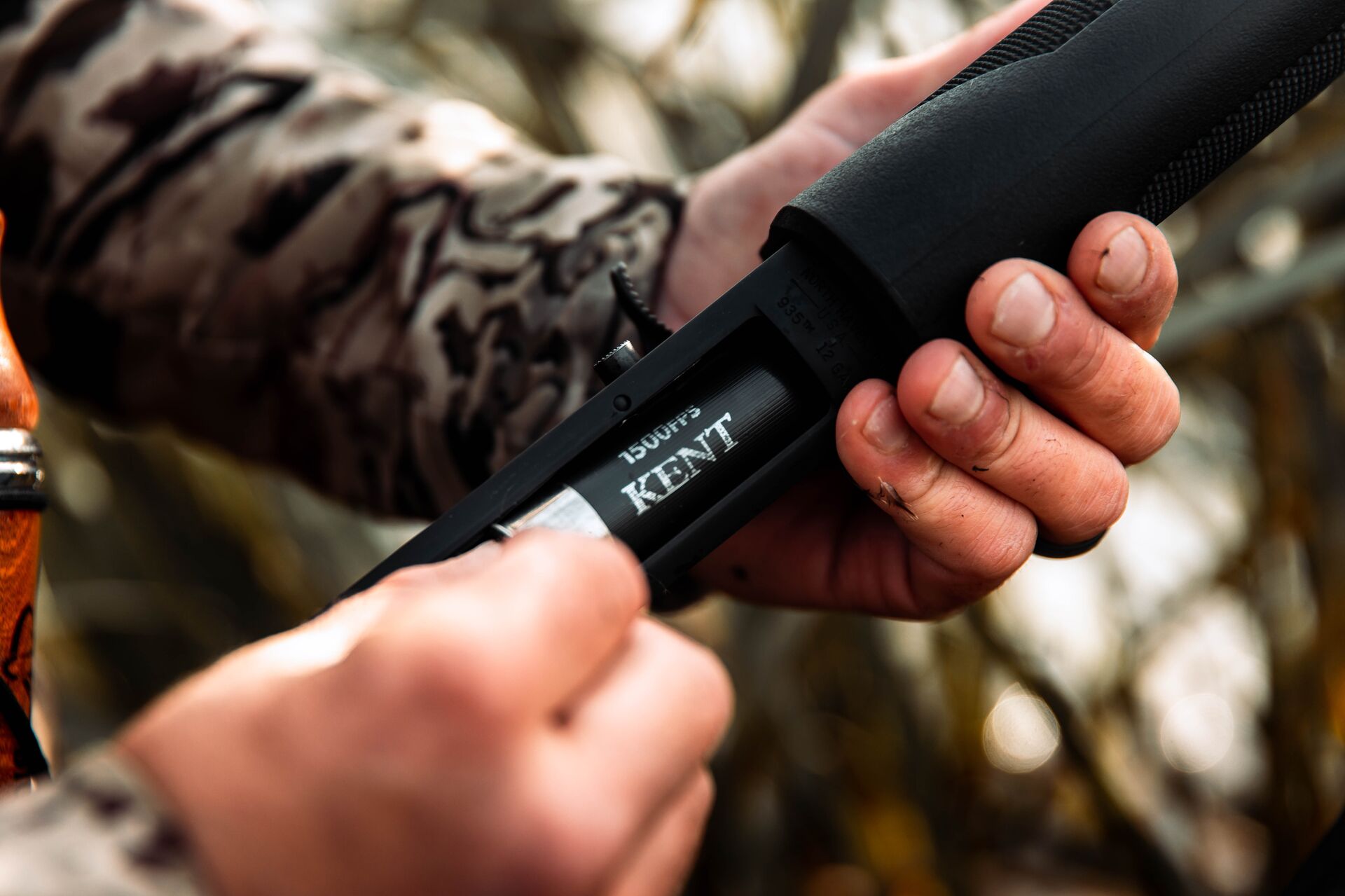 Close-up of a hunter loading a shell into a shotgun, the basic parts of ammunition concept. 